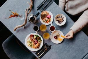 a table with plates of food on it at Lapland Hotels Ounasvaara Chalets in Rovaniemi
