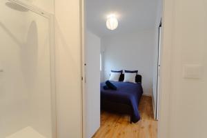 a bedroom with a bed with blue sheets and pillows at T2 moderne Mon Toit in Mont-de-Marsan +24 photos