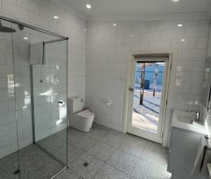 a bathroom with a toilet and a shower and a sink at Annabelle's Cottage in Clare