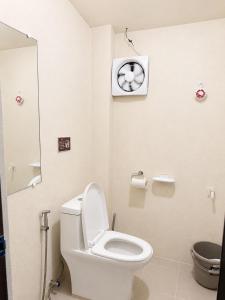 a bathroom with a toilet and a clock on the wall at Bayay Isla Inn in General Luna