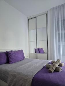 a bedroom with a large bed with purple pillows at Apartments Bujkovic in Bar