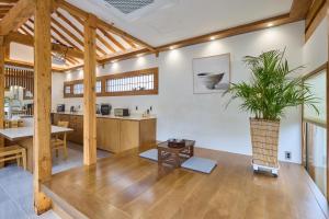 a living room with a table and a plant in a vase at Hanok spa stay 소연정 in Andong