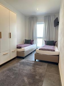 a bedroom with two beds and a window at Pension Boardinghaus Dingolfing in Dingolfing +10 photos