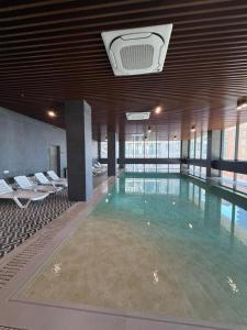 a large swimming pool in a large building at Komunna Luxe in Batumi