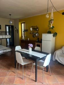 a dining room with a black table and white chairs at Nùi Homestay in Monastero di Lanzo