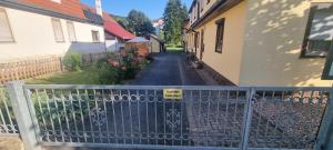 a fence in front of a house with a driveway at Ferienwohnung Bodenstein in Bad Liebenstein