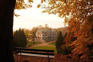 a park bench in front of a large house at Ferienwohnung Bodenstein in Bad Liebenstein +11 photos