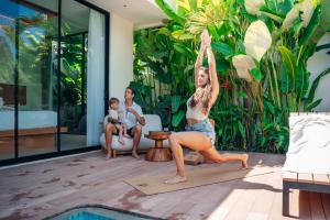 a woman doing a yoga pose next to a pool at Candidasa Hills in Candidasa