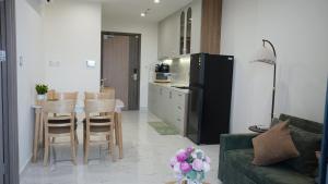 a living room with a kitchen with a table and a refrigerator at 2BR-2WC-Vinhomes Grand Park-Sunset View-VincomMeGaMall-WindyHomes in Long Bình +35 photos