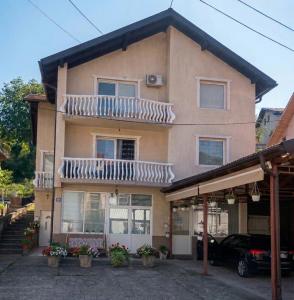 a house with a balcony on top of it at Apartmani Lazaro in Višegrad