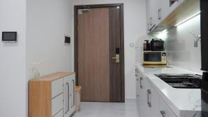 a kitchen with white counters and a wooden door at 2BR-2WC-Vinhomes Grand Park-Sunset View-VincomMeGaMall-WindyHomes in Long Bình