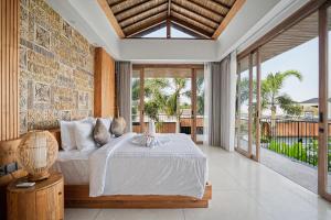 a bedroom with a bed and a large window at Casa de Rua Villas in Badung