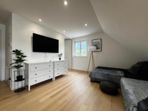 a living room with a white dresser with a flat screen tv at Living by Maier Altach in Altach +32 photos