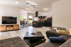 a living room with a couch and a flat screen tv at Ferienwohnung Hopf in Bad Liebenstein +8 photos