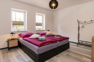 a bedroom with a large bed with red sheets at Ferienwohnung Hopf in Bad Liebenstein