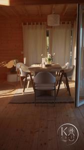 a dining room table with white chairs in a house at Koochill in Koczała +13 photos