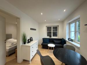 a living room with a blue couch and a table at Living by Maier Altach in Altach