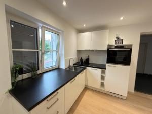 a kitchen with white cabinets and a black counter top at Living by Maier Altach in Altach