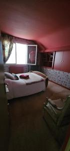 a bedroom with a bed and a chair in it at Chambre d'hôtes Le Havre in Saint-Coulomb