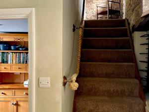 a stairway with a teddy bear hanging from a door at Lamorna Cottage in Chipping Norton