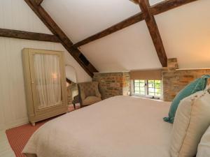 a bedroom with a large bed and a chair at The Farmhouse in Langport