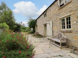 a bench sitting outside of a brick building at The Farmhouse in Langport