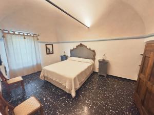 a bedroom with a bed and a table and a chair at Corte CeLestiale in Albenga