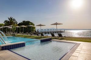 a swimming pool with chairs and umbrellas next to the water at Hotel Ocelle Thermae & Spa - Adults Only in Sirmione +43 photos