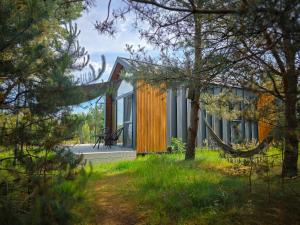 a house in the woods with a tree at Dywanowy Zakątek in Sominy