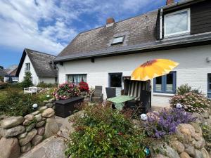 a house with a table and an umbrella in a garden at Moby Dick im Haus Käpt'n Andresen in Westerland