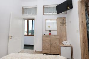a bedroom with white walls and a wooden door at Guest House Eno in Berat