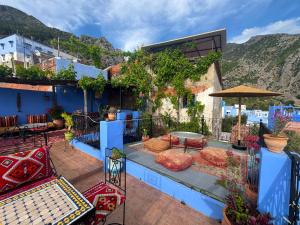 a patio with blue walls and a table and chairs at Dar Yamina Andalusi in Chefchaouen