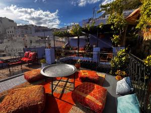 a patio with a table and chairs on a balcony at Dar Yamina Andalusi in Chefchaouen +47 photos