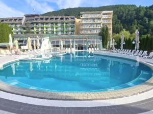 a large swimming pool in front of a hotel at Apartment HORTENZIJA near Terme Topolšica in Topolšica