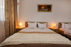 a bedroom with two beds and two lamps on tables at Guest House Eno in Berat
