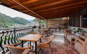 a restaurant with tables and chairs on a balcony at Guest House Eno in Berat