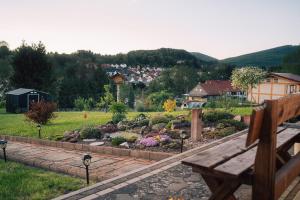 a park with a bench and a garden with flowers at Ferienwohnung Altensteinblick in Bad Liebenstein