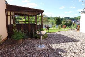 a garden with a small building and a bird feeder at Ferienwohnung Altensteinblick in Bad Liebenstein