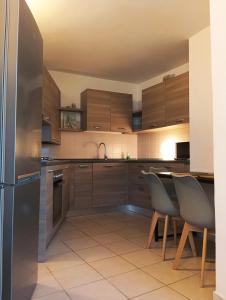 a kitchen with wooden cabinets and a stainless steel refrigerator at Mountain Suite in Raveo