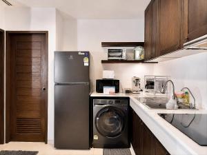 a kitchen with a refrigerator and a dishwasher at Las Tortugas beach front condo in Khao Tao