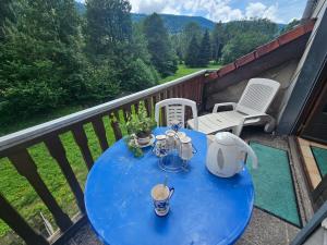 a blue table on a balcony with a tea set on it at appartement le petit chalet sauna in La Bresse