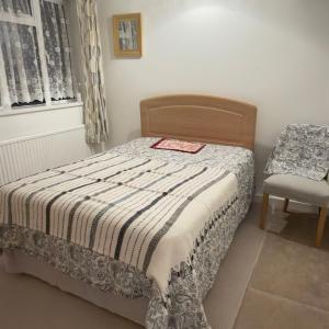 a small bedroom with a bed and a chair at A beautiful stylish home in city centre in Camberley +4 photos