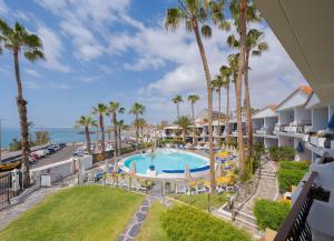 an aerial view of a resort with a pool and palm trees at Sunsuites Carolina in San Agustin