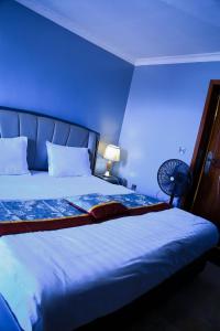 a blue room with a bed with a blue wall at KiGALI COMFORT AND CLASSIC STAY APARTMENT in Kigali