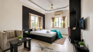 a bedroom with a bed and a couch and a tv at BluO Lake View NewTown - Boutique Hotel in Kolkata