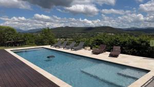 a swimming pool with chairs and a view of mountains at Ermitage Crestet (Ventoux - Provence) in Crestet