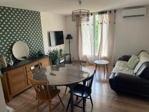 a living room with a table and a couch at Appartement Cosy in Manosque