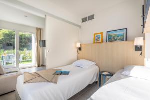 a hotel room with two beds and a window at Résidence Pierre et Vacances Cap Cassis Calanques in Roquefort-la-Bédoule