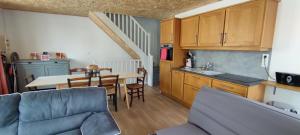 a kitchen and living room with a couch and a table at DUPLEX DE LA MOTTE in Beaumont-sur-Sarthe