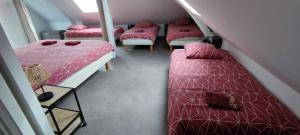 a attic room with four beds and a staircase at DUPLEX DE LA MOTTE in Beaumont-sur-Sarthe